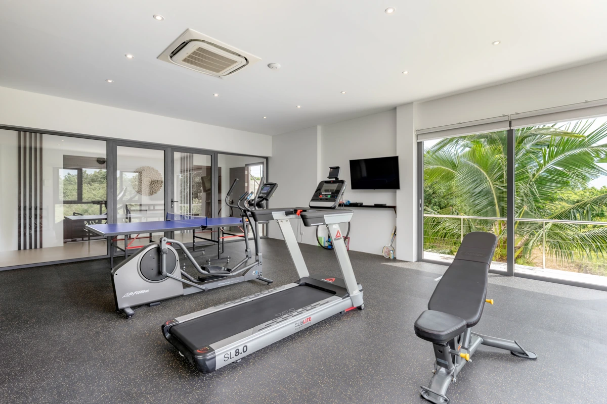 The private gym with exercise equipment and a table tennis table