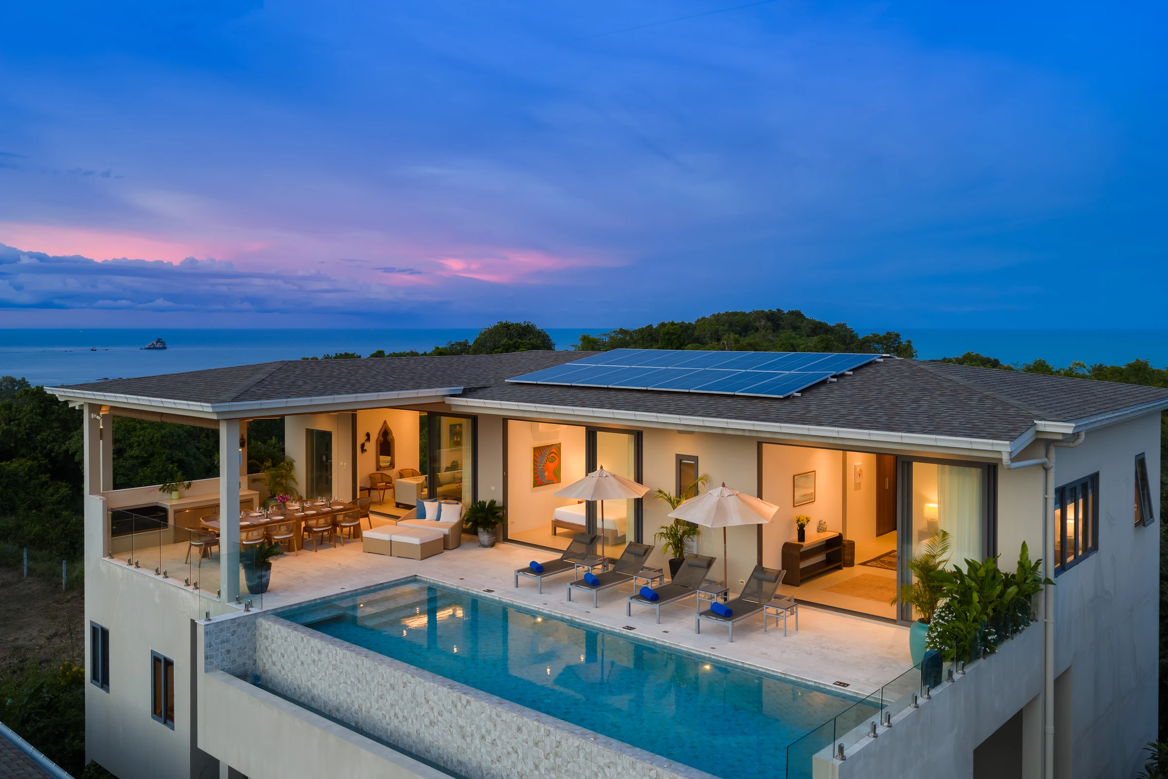 The illuminated villa and infinity pool at dusk